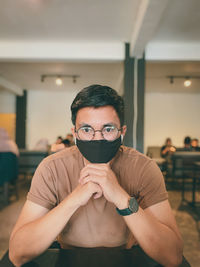 Portrait of young man wearing mask at restaurant