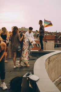 Friends arranging blanket on terrace for rooftop party in city
