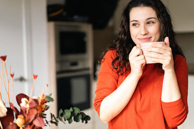 Portrait of young woman using mobile phone at home