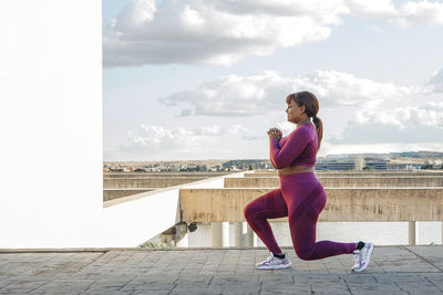 Young black woman exercising, doing lunges