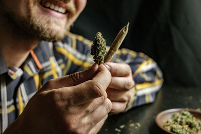 Close-up of man holding marijuana