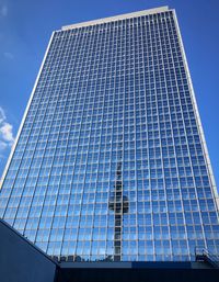 Low angle view of office building against blue sky
