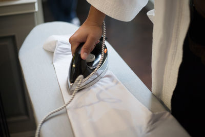 Cropped image of person ironing at home 