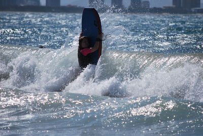 Young woman surfing in sea