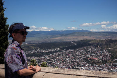 Man on retaining wall against mountain