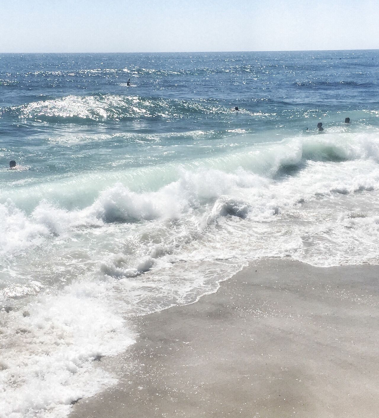 Swimming with the wave shades of blue water daylight shoreline Sandy beach vacation spot and a family travel destination