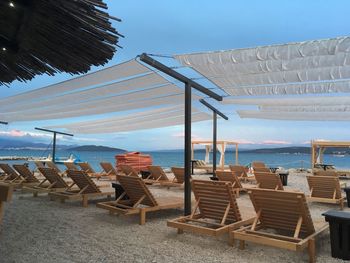 Chairs on beach against sky