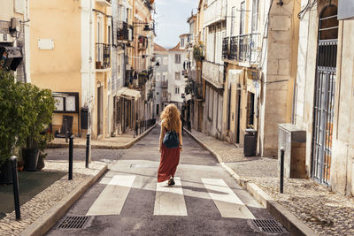 Woman walking against houses