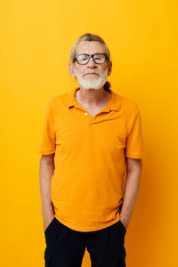 Portrait of senior man against yellow background