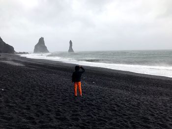 Rear view of man standing on beach