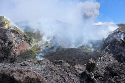 Smoke emitting from volcanic mountain against sky