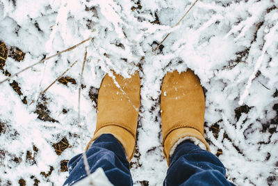 Low section of woman standing on snow covered land