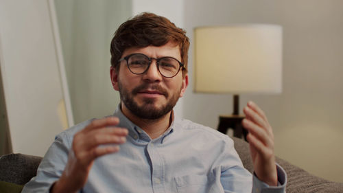 Portrait of young man using smart phone at home