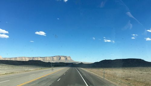 Road amidst landscape against blue sky