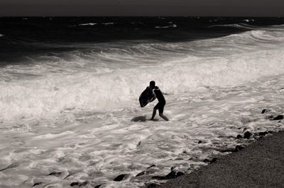 Surfer walking at beach