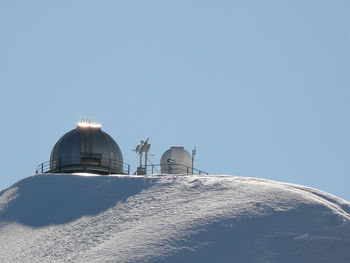 Low angle view of snow covered landscape against clear sky