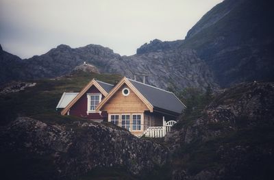 House amidst rocks and mountains against sky