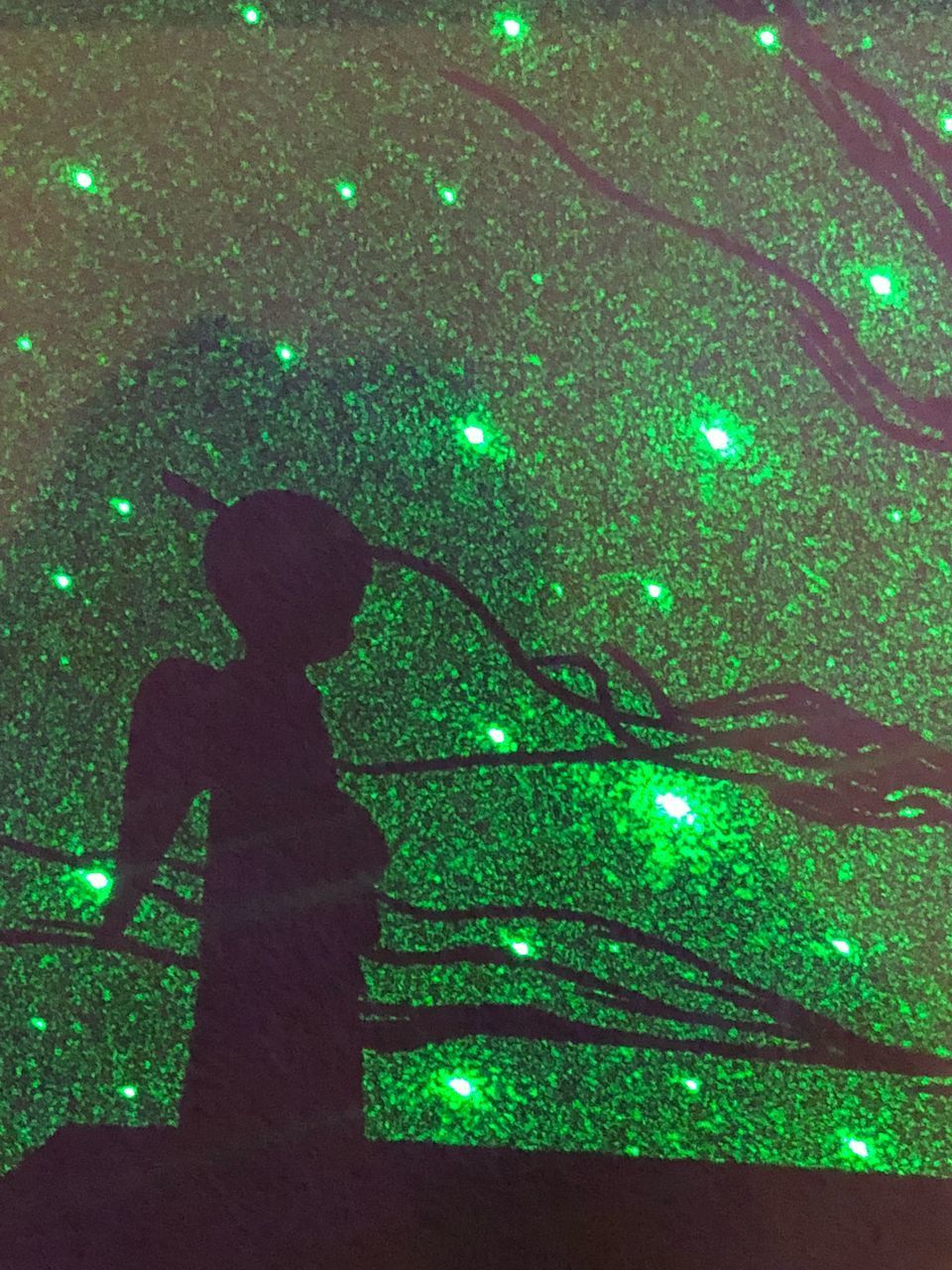 WOMAN STANDING IN ILLUMINATED TREE