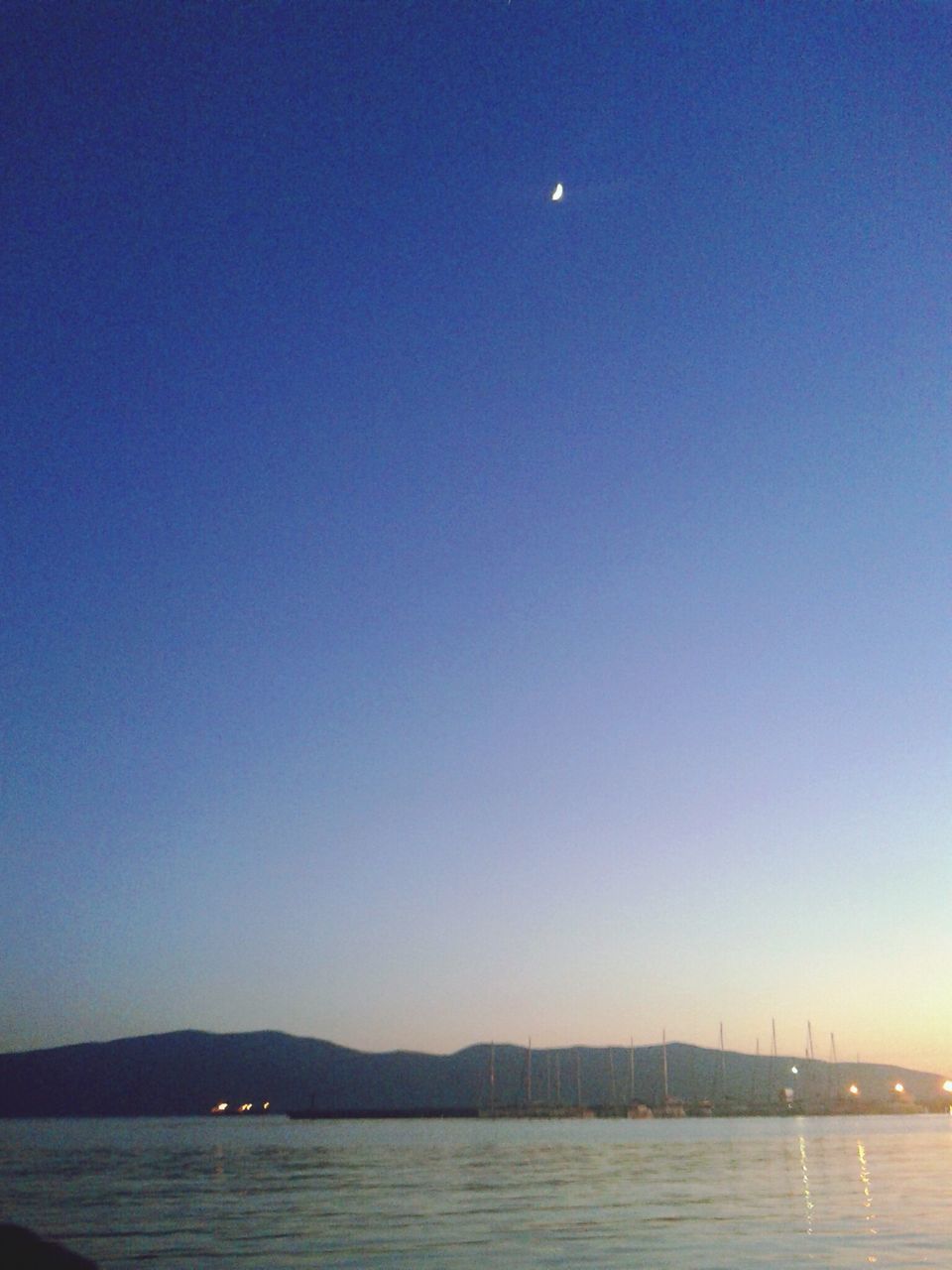 water, clear sky, copy space, waterfront, sea, tranquil scene, scenics, tranquility, blue, night, illuminated, beauty in nature, moon, nature, dusk, idyllic, transportation, outdoors, river, ocean