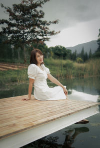 Side view of woman sitting in boat in lake