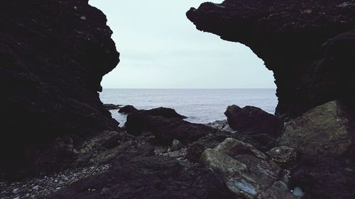 Close-up of rocks in sea against sky