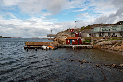 Houses by sea against sky