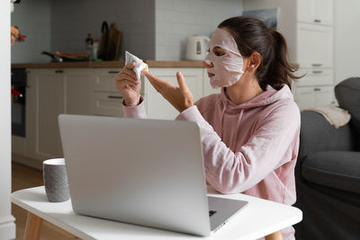 Woman sitting on table at home