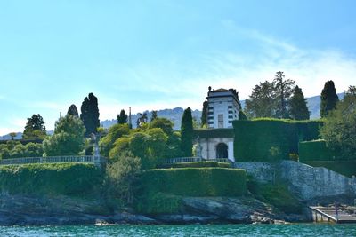 View of castle by river against blue sky