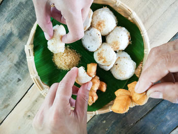 High angle view of hands holding food on table