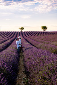 Side view of couple standing on field against sky