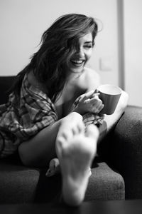 Woman holding coffee cup sitting at home