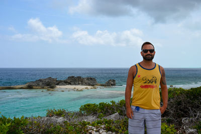 Portrait of man standing at sea against sky