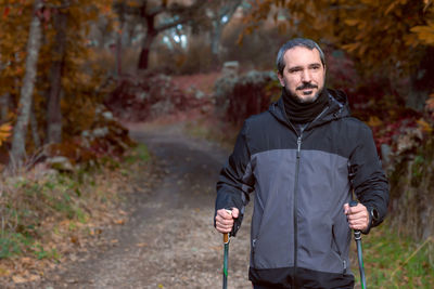 Man looking away while standing on footpath