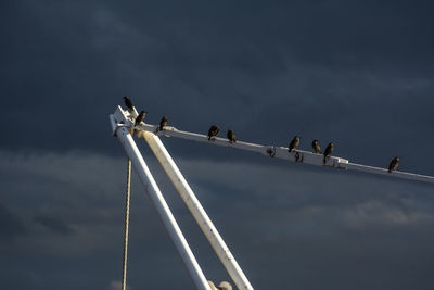 Low angle view of people on bridge against sky