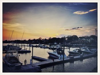 Boats in harbor at sunset