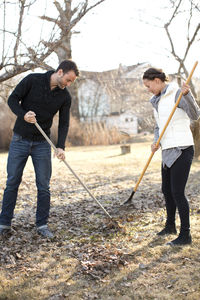 Couple raking leaves in garden, stockholm, sweden