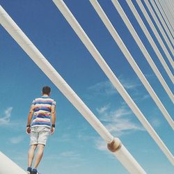 Low angle view of people against blue sky