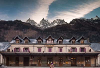 Houses against buildings and mountains against sky