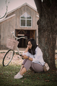 Side view of young woman sitting on field