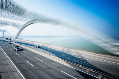 Aerial view of bridge over road against blue sky