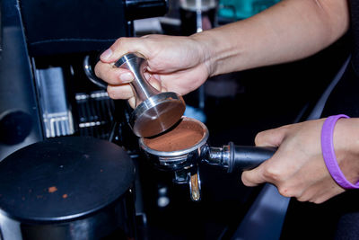 Close-up of man pouring coffee in cafe