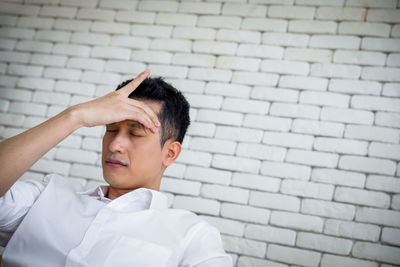 Portrait of man against brick wall