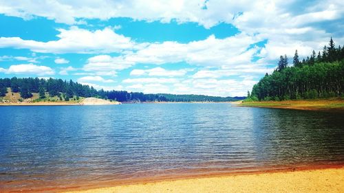 Scenic view of lake against cloudy sky