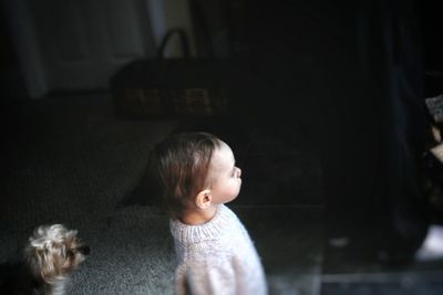 High angle view of cute baby girl looking away standing at home
