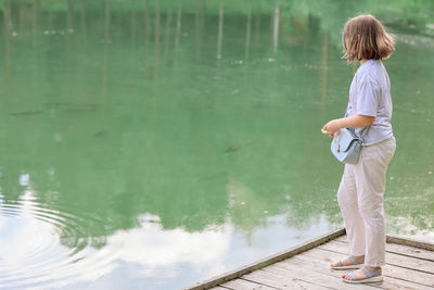 A girl on the shore of the lake with fish on a summer day person