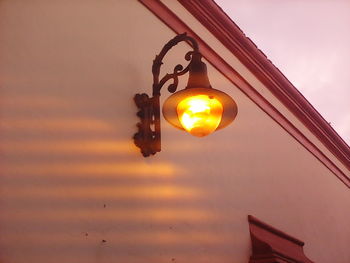 Low angle view of lighting equipment hanging against sky