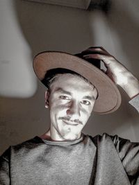 Portrait of young man wearing hat at home