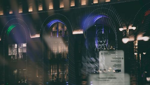 Illuminated city seen through window at night