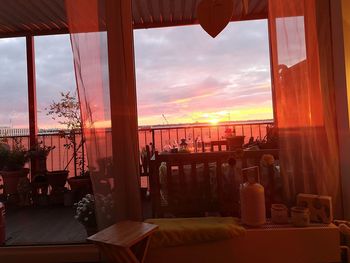 Chairs and table at restaurant against sky during sunset