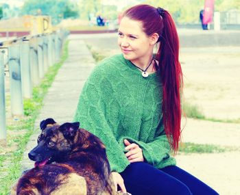 Portrait of woman with dog sitting outdoors